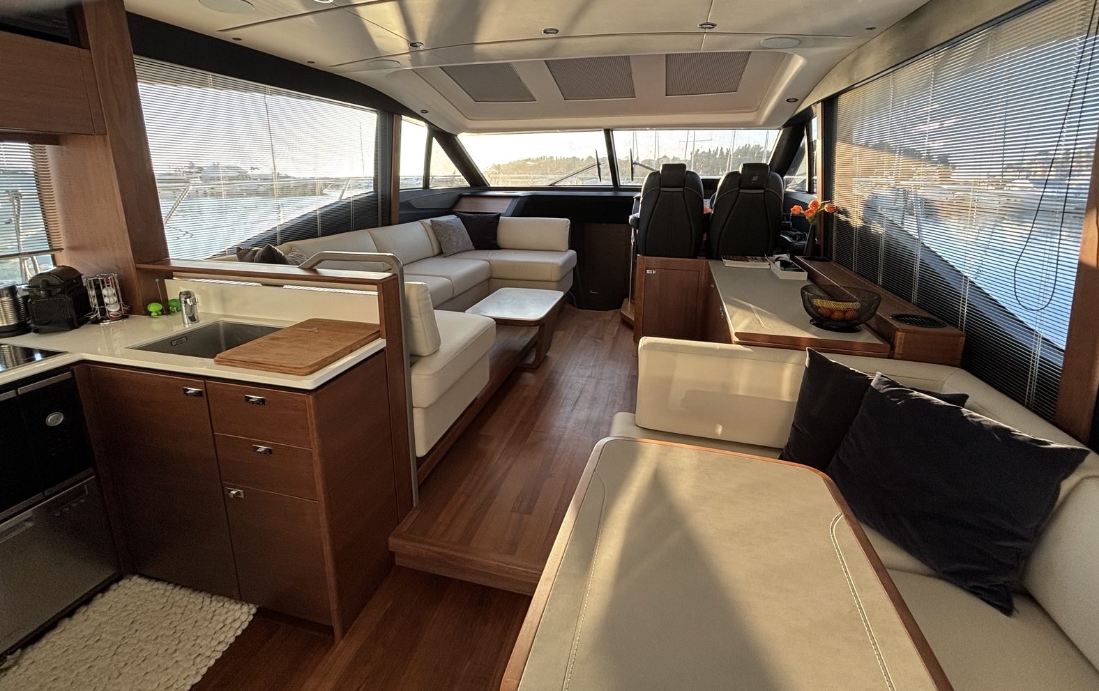 Main deck salon with open galley, dining table and panoramic windows